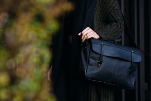 Close-up of a leather messenger bag being carried in Portland, showcasing style and fashion.